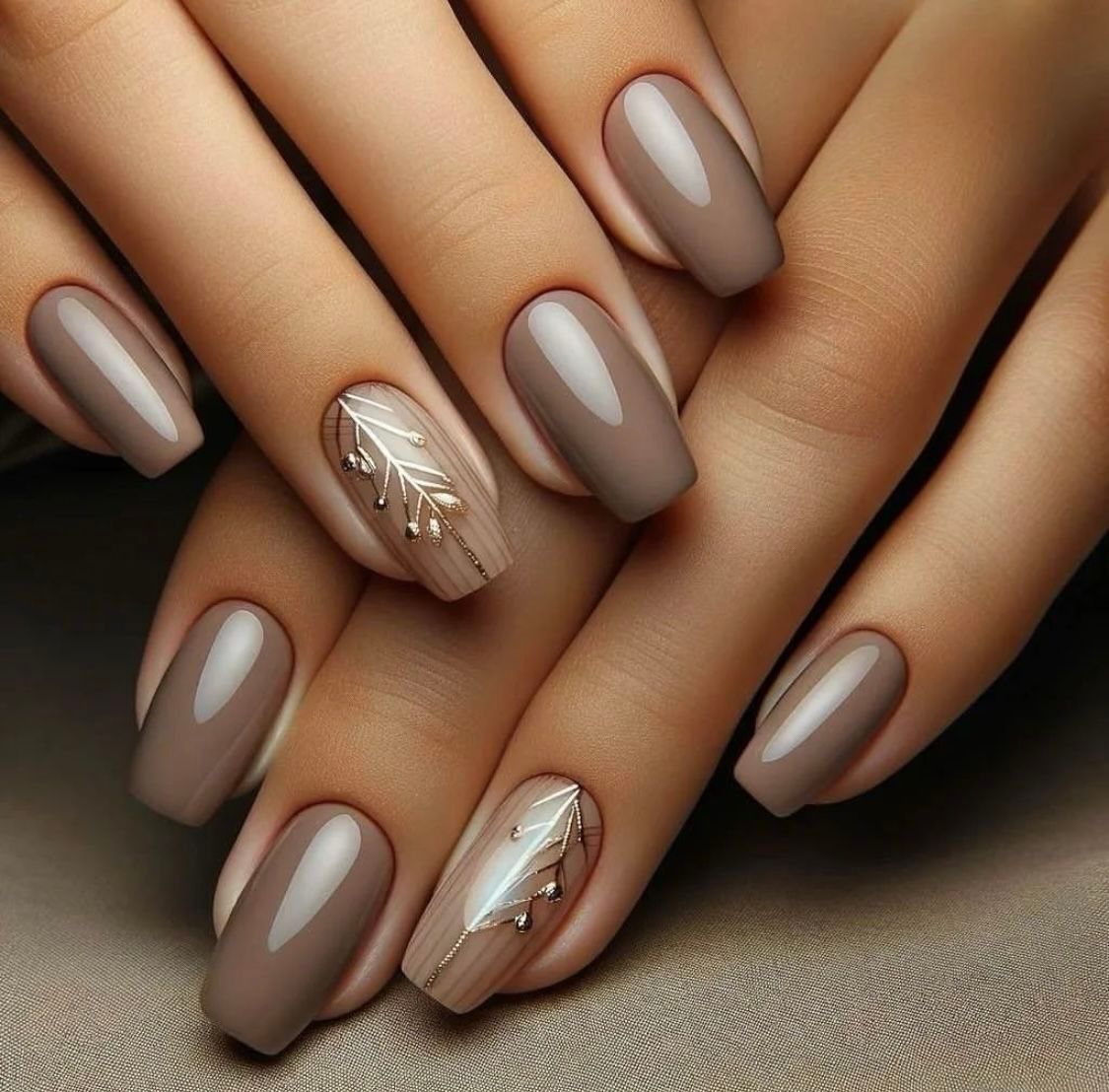 Manucure de fête discrète couleur taupe avec motif feuille dorée