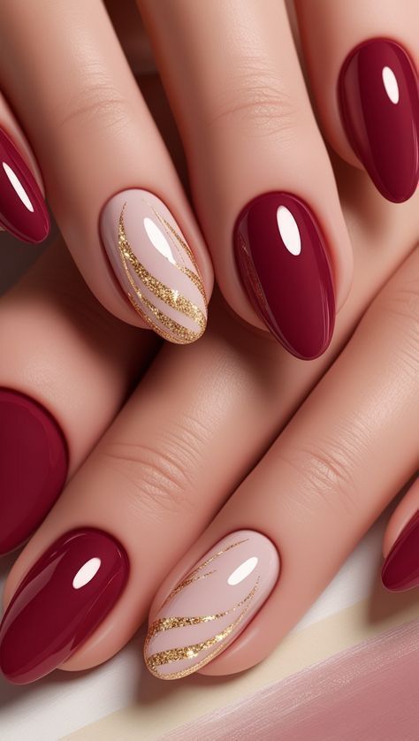 Élégante manucure en amande alternant des ongles framboise unis et des ongles nudes décorés de volutes de paillettes dorées.
